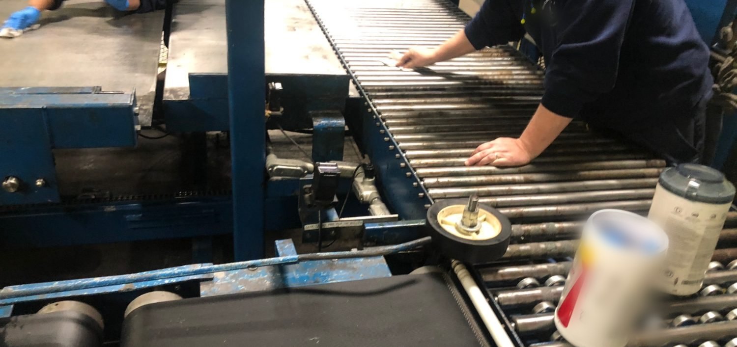 Hands cleaning and inspecting conveyor rollers